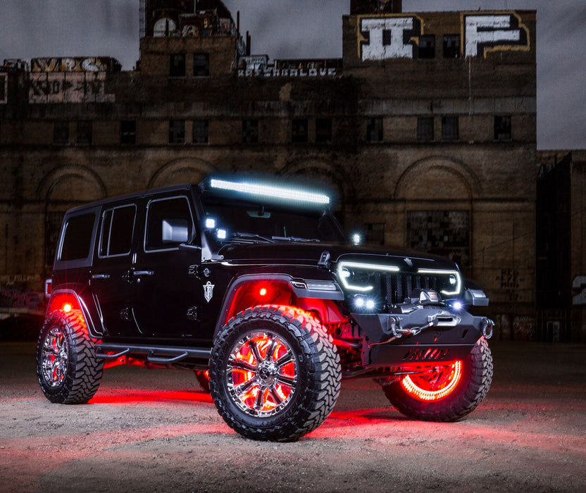 Front three quarters view of a black Jeep with various LED lighting products installed, in front of a warehouse.