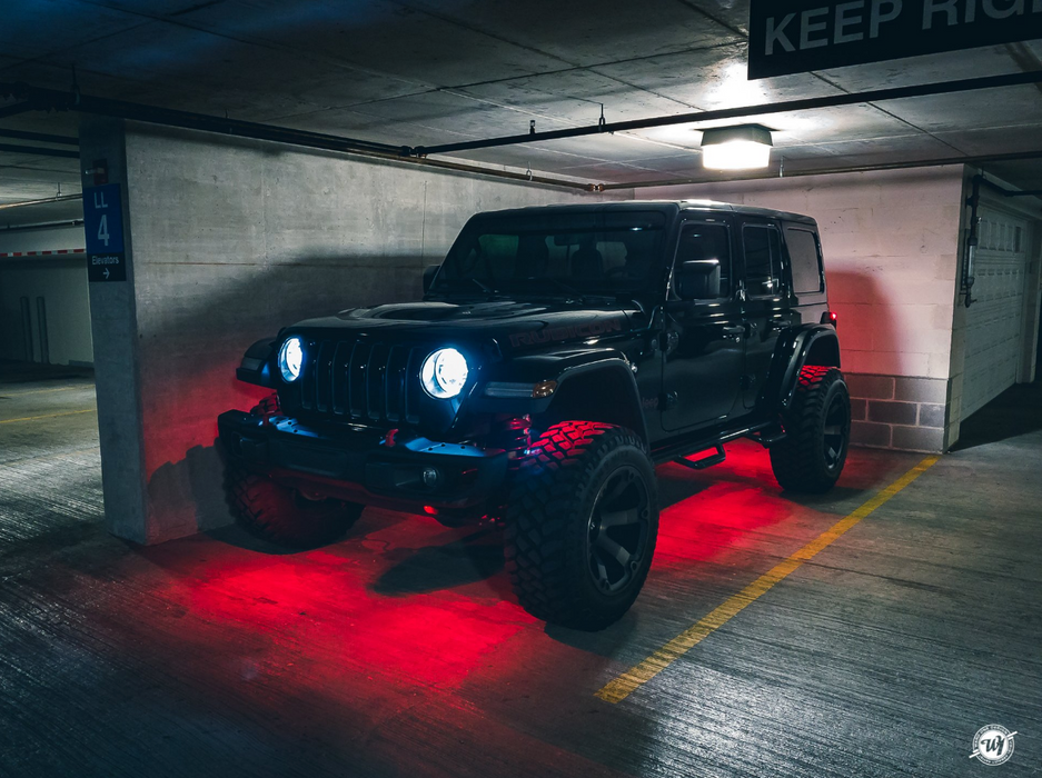 Jeep in a parking garage with red rock lights turned on.