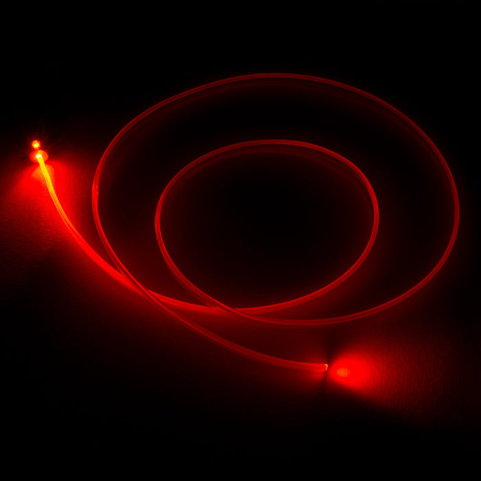 A fiber optic cable attached to a light head, glowing red.