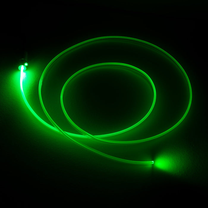 A fiber optic cable attached to a light head, glowing green.