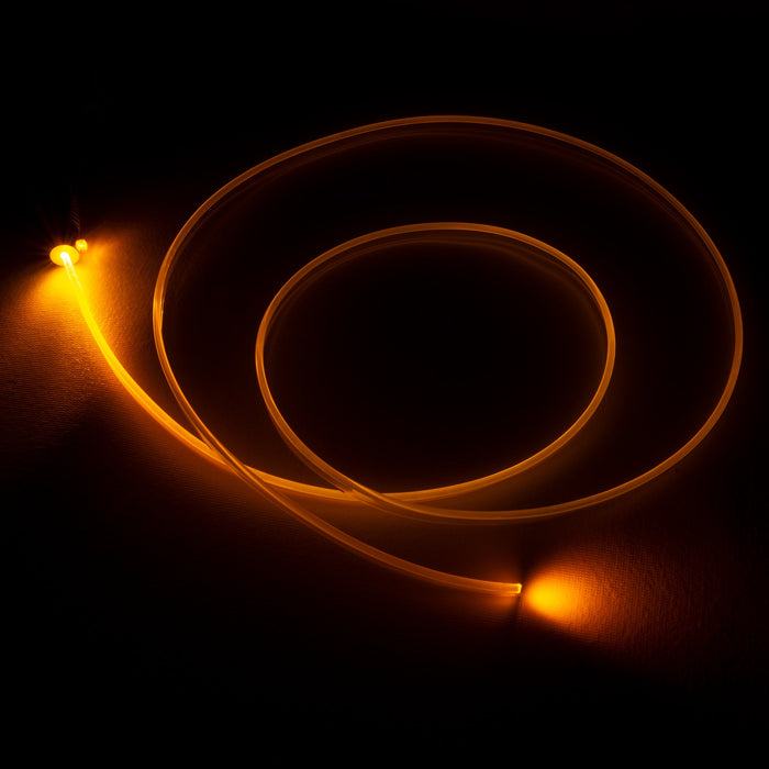 A fiber optic cable attached to a light head, glowing amber.