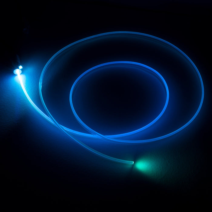 A fiber optic cable attached to a light head, glowing cyan.