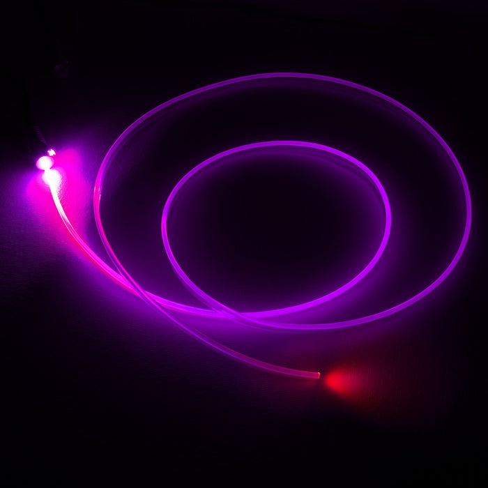 A fiber optic cable attached to a light head, glowing pink.