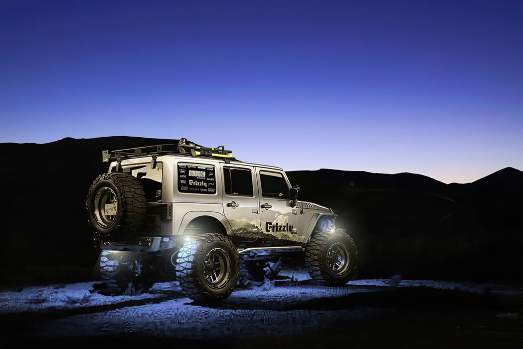 Jeep outdoors with white rock lights glowing.
