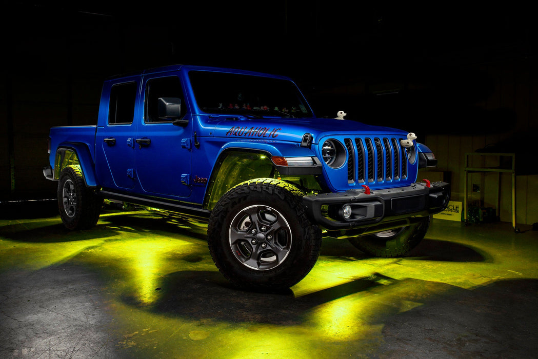 Three quarters view of a blue Jeep Gladiator JT with rock lights set to yellow.