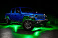 Three quarters view of a blue Jeep Gladiator JT with rock lights set to green.