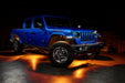 Three quarters view of a blue Jeep Gladiator JT with rock lights set to amber.