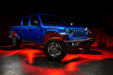 Three quarters view of a blue Jeep Gladiator JT with rock lights set to red.