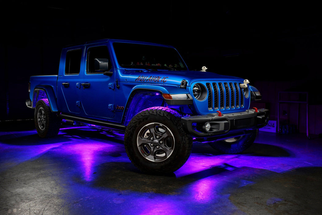 Three quarters view of a blue Jeep Gladiator JT with rock lights set to purple.
