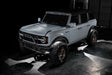 Top three quarters view of a grey Ford Bronco with white LED rock light kit.