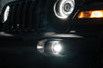 Front end of a Jeep with High Performance 20W LED Fog Lights installed and turned on.