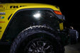 Close up on the front wheel well of a yellow jeep, with rock lights set to white LED.