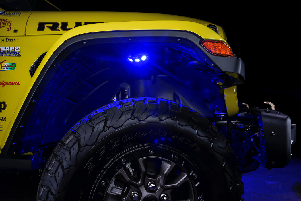 Close up on the front wheel well of a yellow jeep, with rock lights set to blue LED.