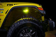 Close up on the front wheel well of a yellow jeep, with rock lights set to yellow LED.