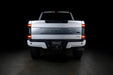 Straight rear view of a white Ford Superduty with Flush Mount Tail Lights installed and DRLs on.