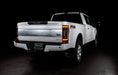 Rear three quarters view of a white Ford Superduty with Flush Mount Tail Lights installed, and DRLs on.