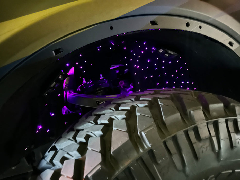 Close-up of fiber optic wheel liner kit installed on bronco with purple LED lighting.