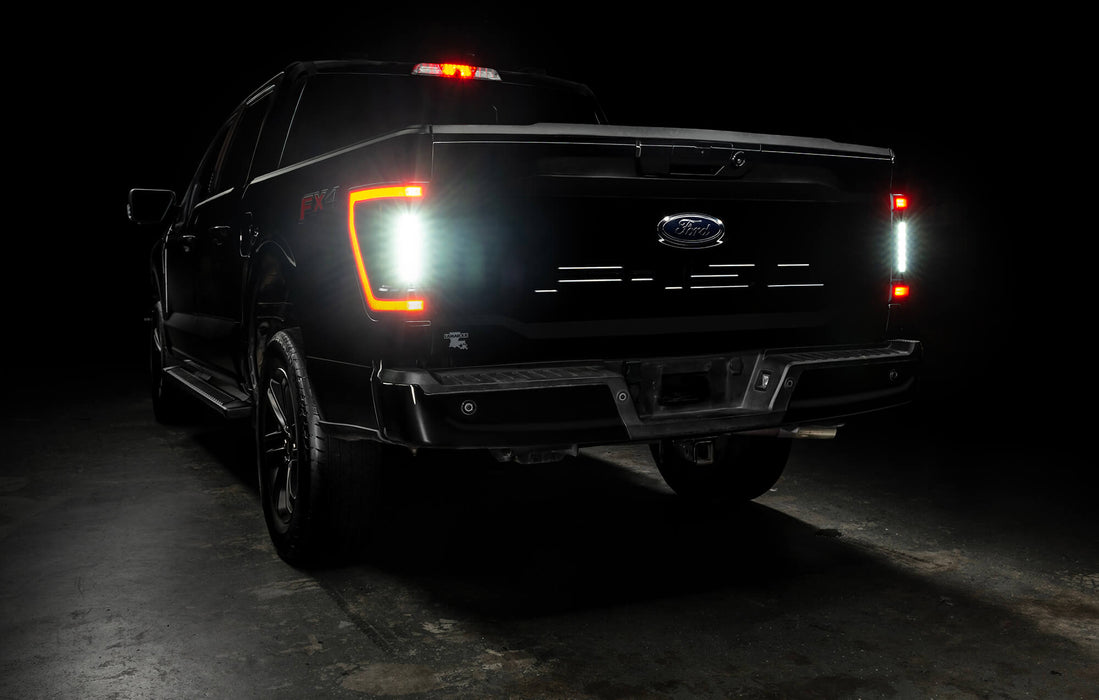 Rear three quarters view of black Ford F-150 with Flush Style LED Tail Lights installed and reverse lights on