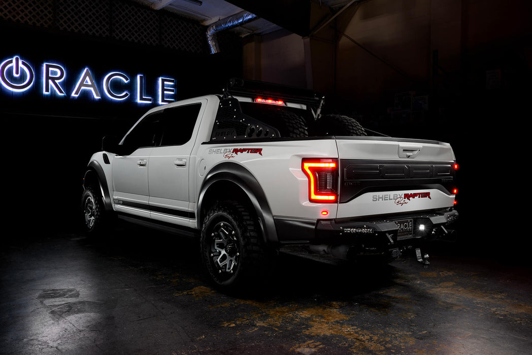 Rear three quarters view of white Ford Raptor with brake lights on