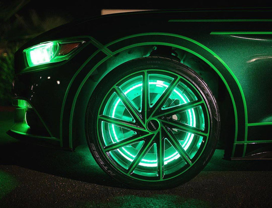 Close up of the wheel well of a green Ford Mustang, with green LED wheel rings installed.