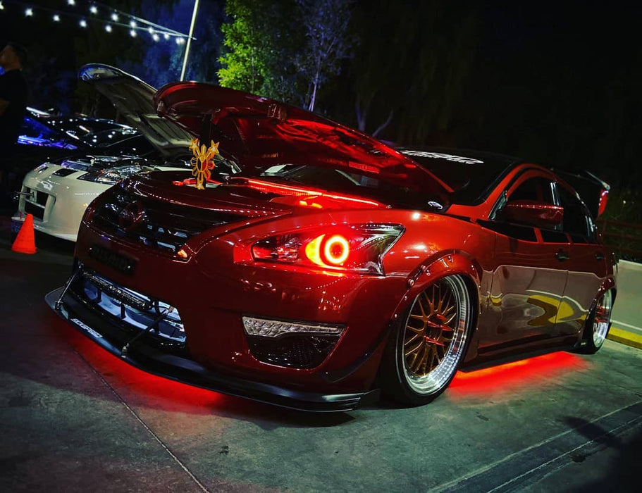 A red Nissan with red halos and red LED underbody kit.
