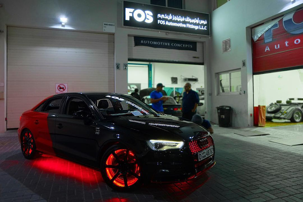 An Audi parked in a garage with red LED wheel rings installed.