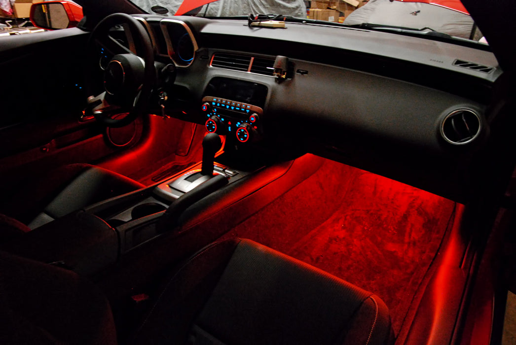 Camaro interior with red ambient footwell lighting.
