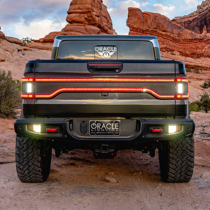 Straight rear view of a Jeep Gladiator JT with multiple LED lighting products installed. Including Flush Mount LED Tail Lights, High Powered Reverse Lights, and Racetrack LED Tailgate Panel.