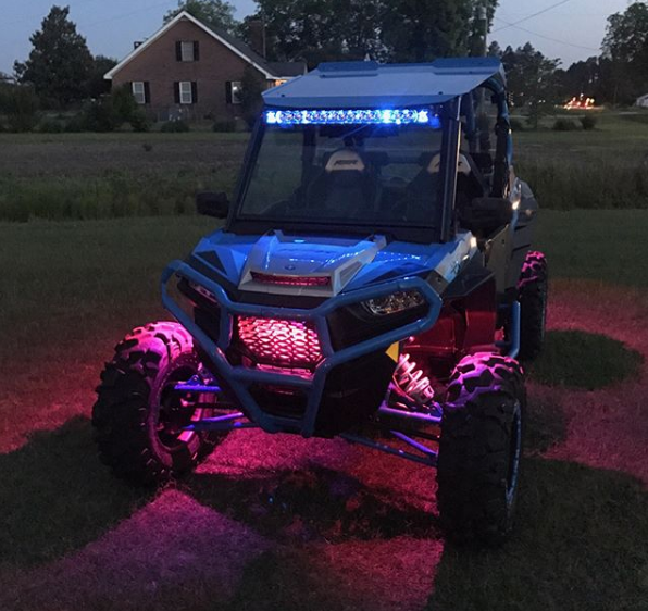 A Polaris with pink rock lights glowing.