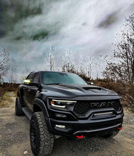 A black RAM TRX on an outdoor trail, with LED Off-Road Side Mirror Ditch Lights shining.