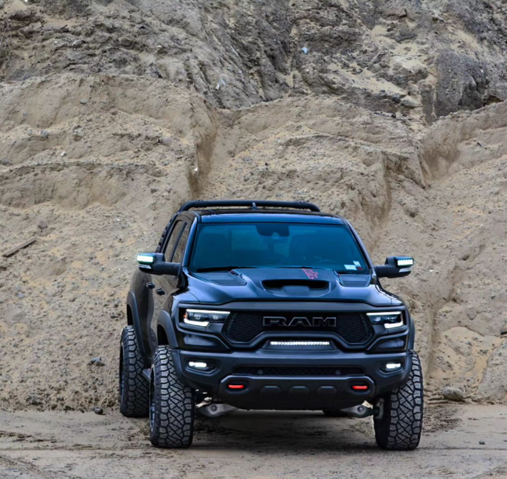 A black RAM TRX on a rocky trail, sporting multiple ORACLE Lighting products.