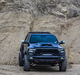 A black RAM TRX on a rocky trail, sporting multiple ORACLE Lighting products.