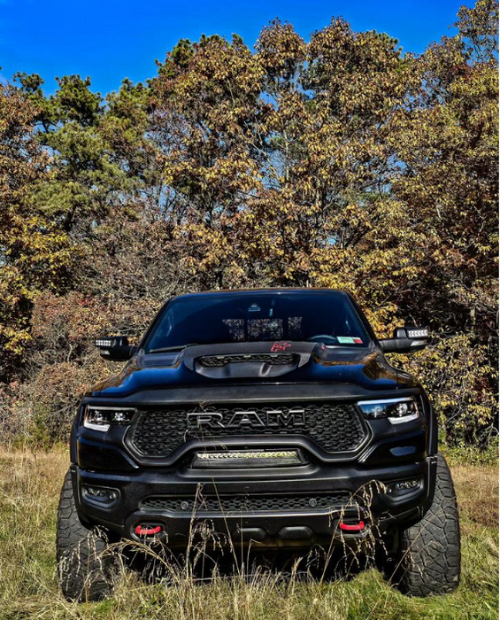 Front view of a black RAM TRX in the grass, with multiple ORACLE Lighting products installed.