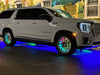 A white GMC Denali with multiple ORACLE Lighting products installed, including Dynamic Colorshift LED Wheel Rings and Fiber Optic Wheel Well Kit.