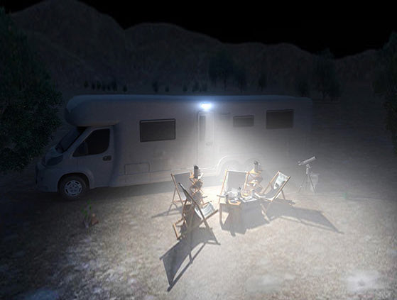 A RV in a desert with the Scene Light illuminating the area next to the RV