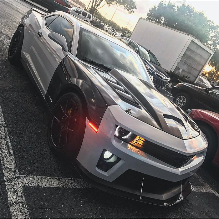 Three quarters view of a Chevrolet Camaro with white LED headlight and fog light halo rings installed.
