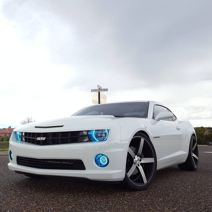 Three quarters view of a Chevrolet Camaro with cyan LED headlight and fog light halo rings installed.