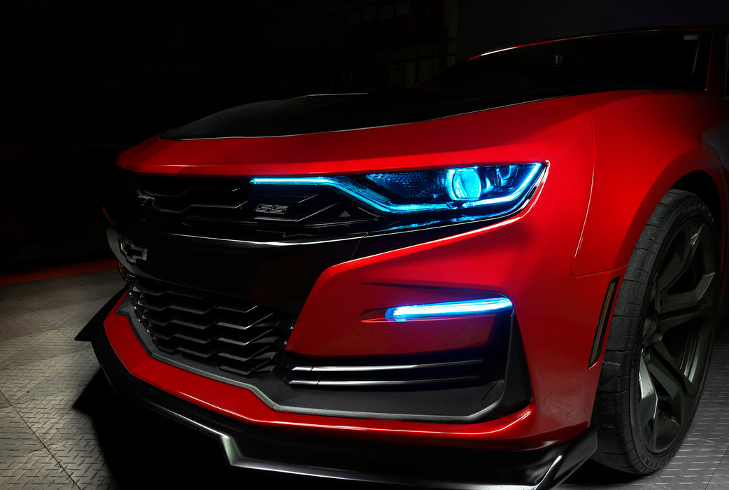Front end of a red Chevrolet Camaro with cyan headlight DRLs.