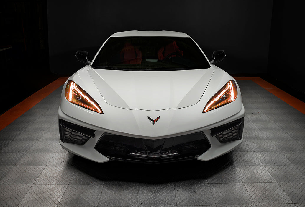 Front view of a white C8 Corvette with amber headlight DRLs.