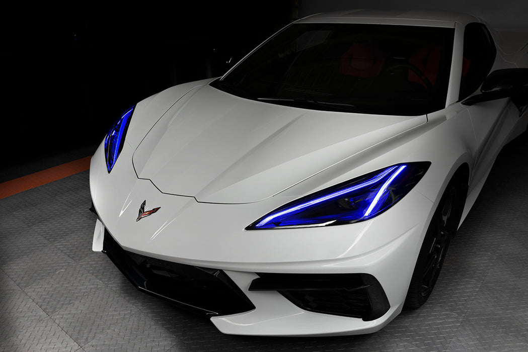 Front end of a white C8 Corvette with blue headlight DRLs.