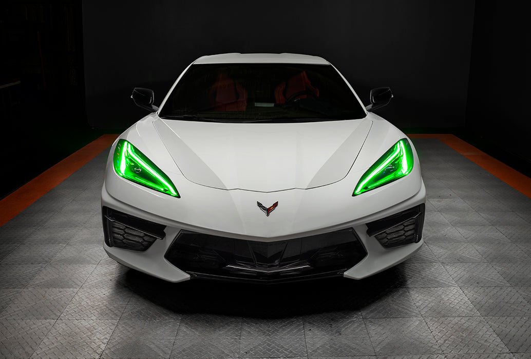 Front view of a white C8 Corvette with green headlight DRLs.