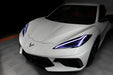 Front end of a white C8 Corvette with white headlight DRLs.