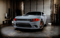 Three quarters view of a grey Dodge Charger with red headlight DRLs.