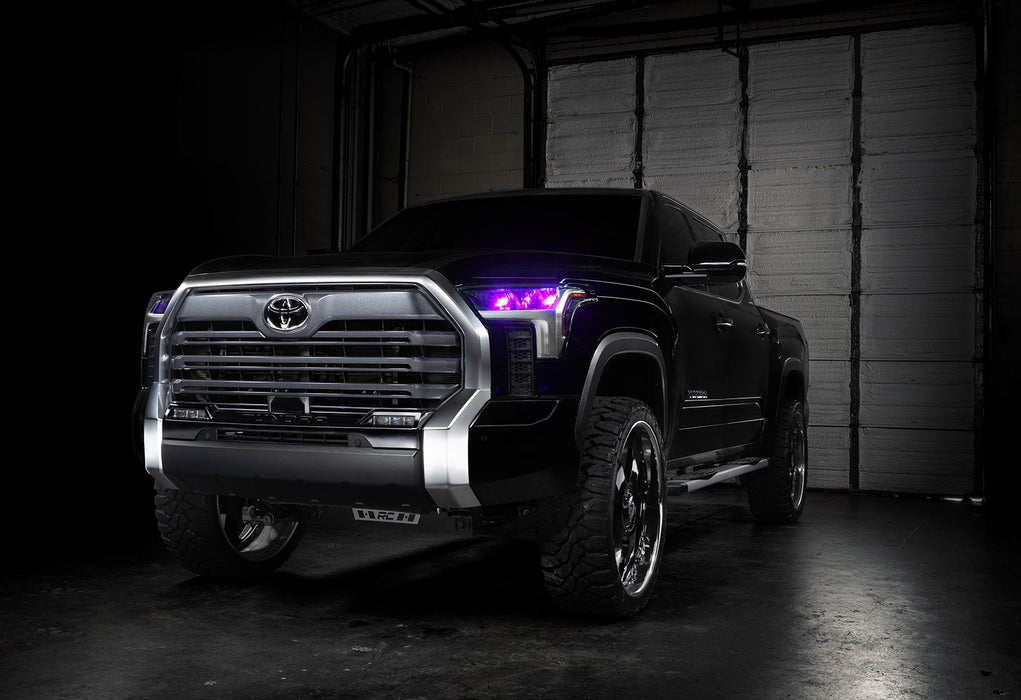 Three quarters view of a black Toyota Tundra with pink demon eye projectors.