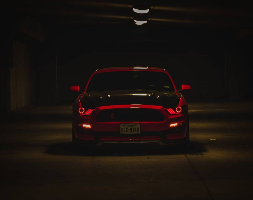 Front of a Ford Mustang with red headlight halos and DRLs.