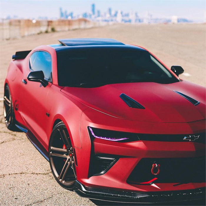 Red camaro in the desert with pink DRLs.