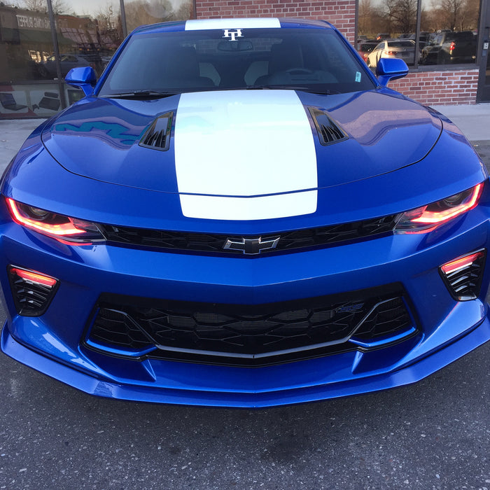Front end of a blue Chevrolet Camaro with red headlight and fog light DRLs.