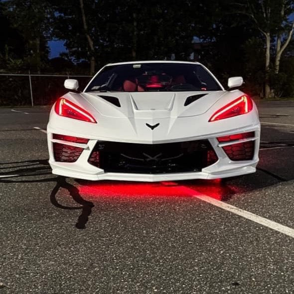 Front view of a white C8 Corvette with red headlight DRLs.