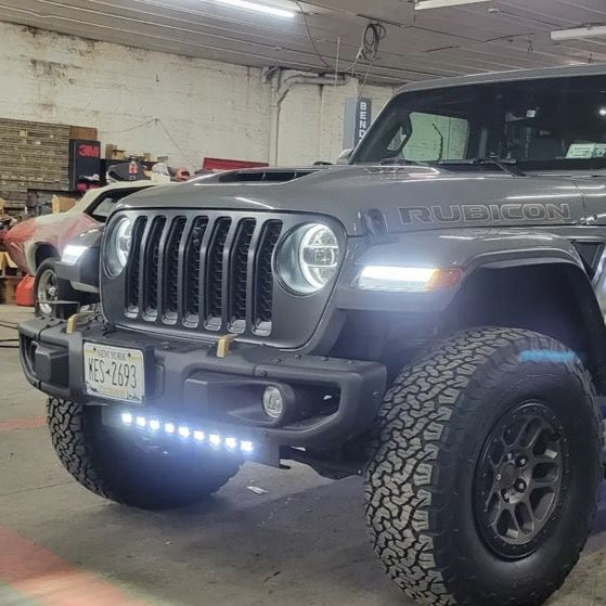 Jeep parked in a garage with multiple lighting products installed and turned on.