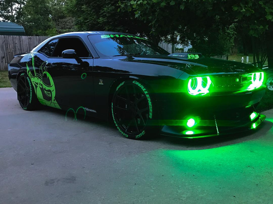 Three quarters view of a black Dodge Challenger with green LED headlight and fog light halo rings installed.